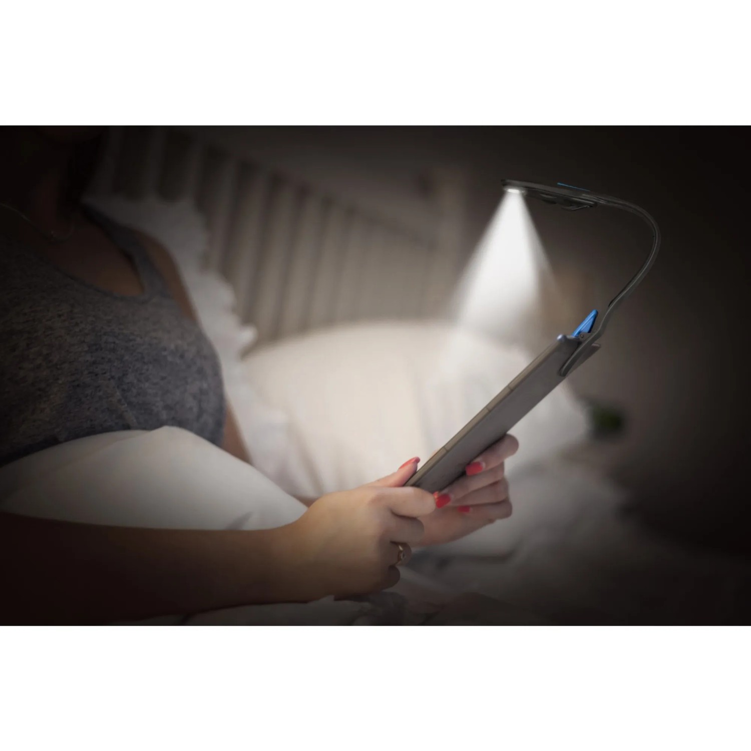 Frau liest mit Energizer Booklight LED Lampe im Bett. Flexible Leselampe mit Klemme.