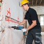 Mann bohrt mit Bosch Professional Bohrhammer GBH 2-28 F in Wand. Inkl. Tiefenanschlag und L-Boxx.