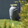 Graue Waterform Regentonne Aquacan 360 l im Amphoren-Design mit Bepflanzung.