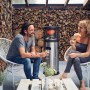 Enders Gas-Terrassenheizer Polo 2.0 mit zwei Personen im Garten. Heizstrahler aus Edelstahl.