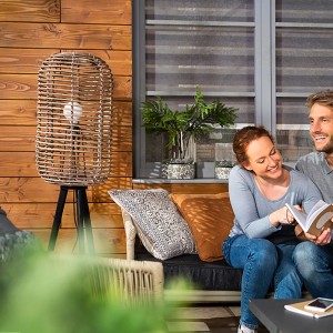 Szene mit Xyladecor Holzschutz-Lasur Ebenholz: Paar liest auf der Terrasse, Holzwand im Hintergrund.