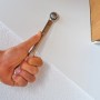 Hand hält Bosch Maulschlüssel aus Werkzeugkoffer Advanced Set an Wand.