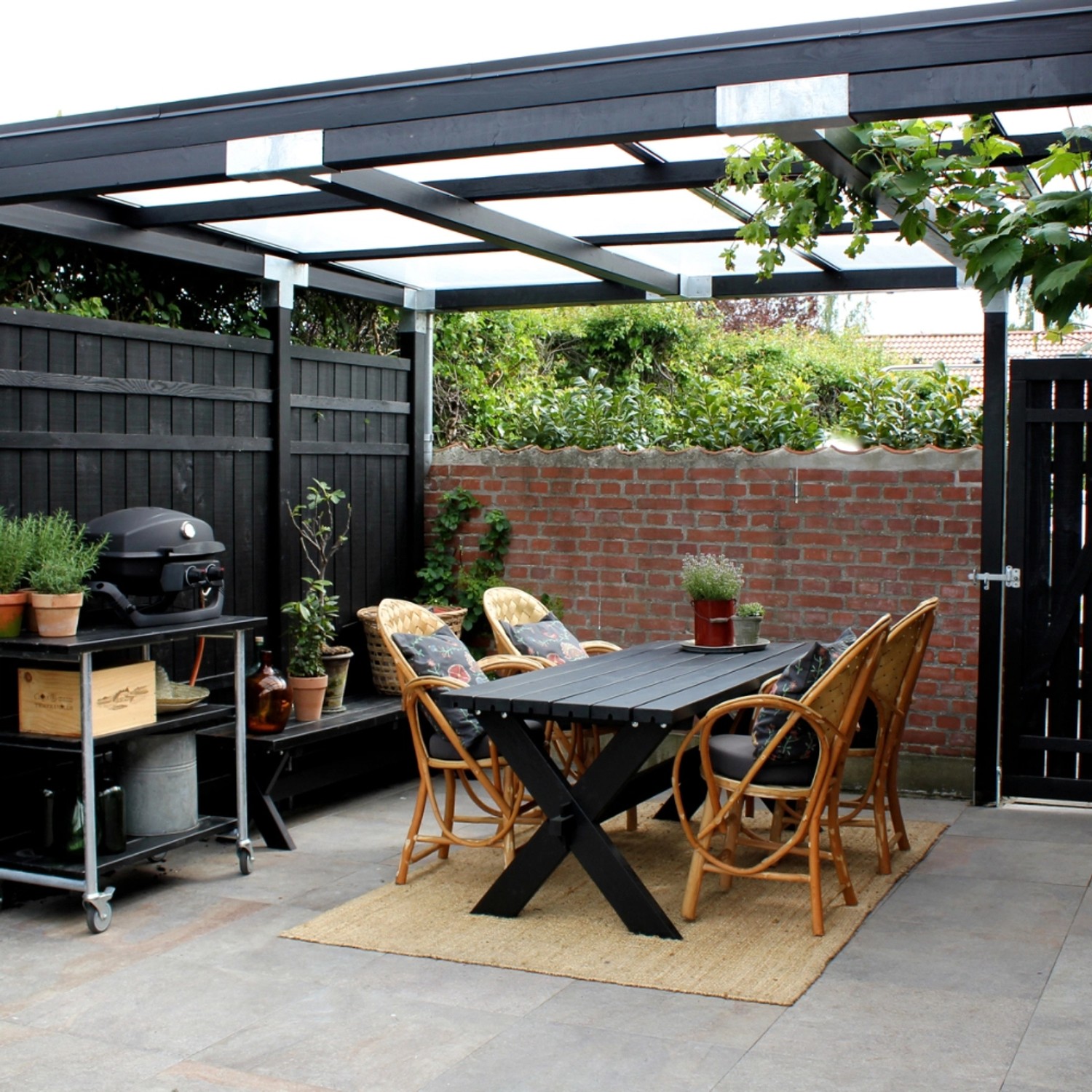 Schwarzes Nadelholz Gartentor Rustik (100x158cm) in Gartenambiente mit Sitzgruppe und Grill.