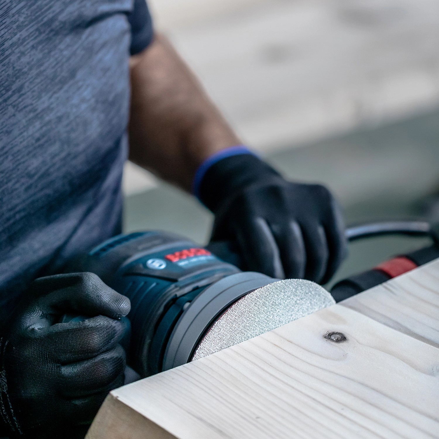 Bosch Expert Netzschleifblatt-Set beim Schleifen von Holz mit Exzenterschleifer.