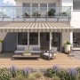 Beige-braune Gelenkarmmarkise Wismar Classic 300x200 cm am Haus montiert.