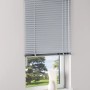 Silberne Aluminium Jalousie Burgos, 100x160 cm, am Fenster mit Blick ins Grüne.