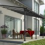 Anthrazitfarbene Palram Canopia Terrassenüberdachung Feria 4x4.2 am Haus mit Tisch und Stühlen.