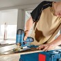 Bosch Professional Akku-Stichsäge GST 12 V-70 in Aktion beim Sägen eines Holzbretts.
