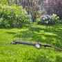 Gardena Viereckregner AquaZoom S beim Bewässern einer Rasenfläche.