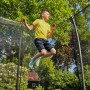 Junge springt auf schwarzem Salta Gartentrampolin Comfort Edition mit Sicherheitsnetz.