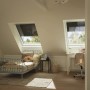 Zwei Dachfenster mit geschlossenem Velux Solar-Rollladen in Alu in einem Kinderzimmer.