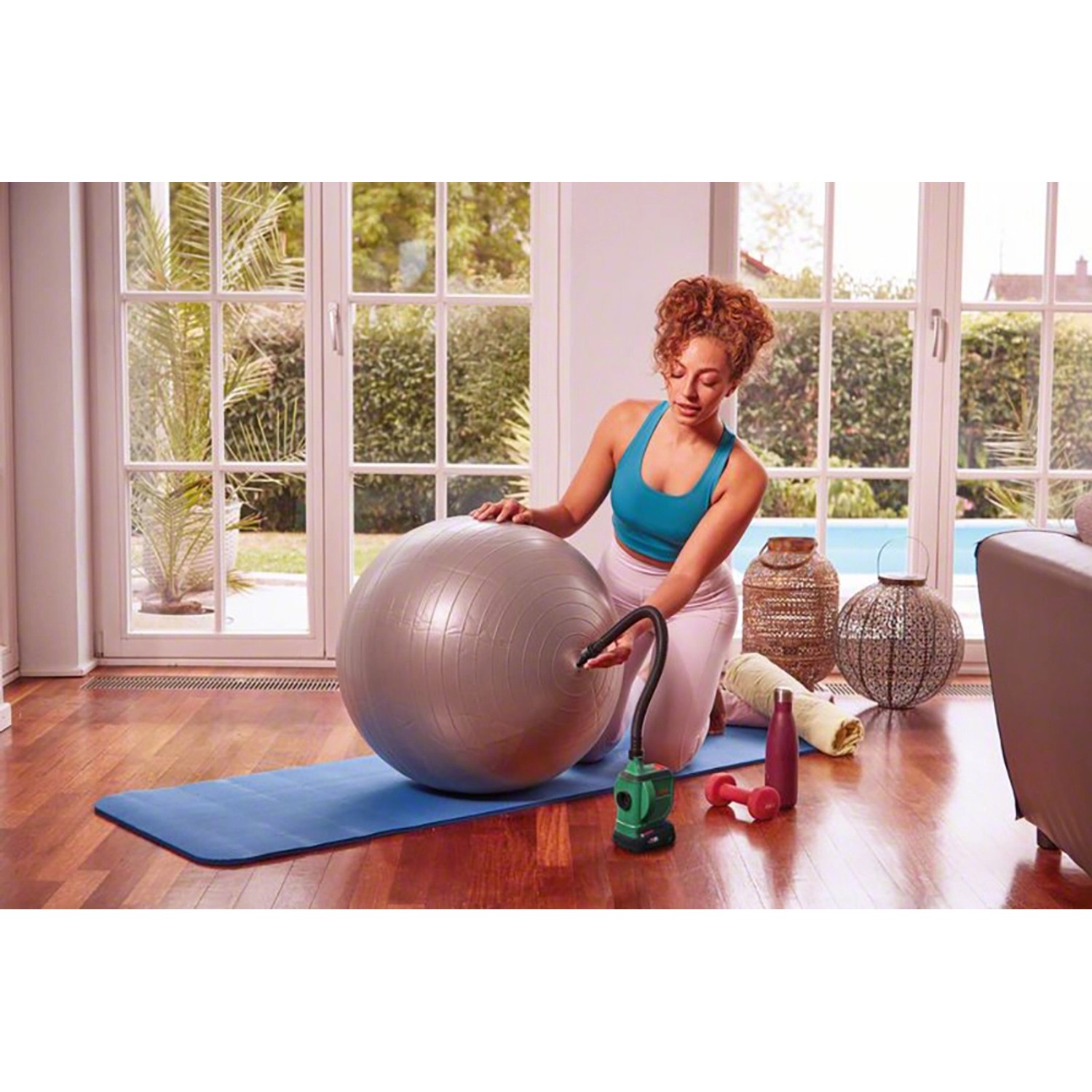 Frau pumpt Gymnastikball mit Bosch Akku-Luftpumpe EasyInflate 18V-500 auf.