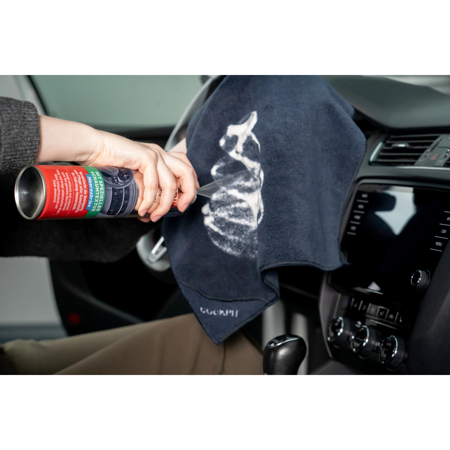 Anwendung: Nigrin Cockpit-Spray Vanille auf Tuch sprühen zur Autopflege und Reinigung.