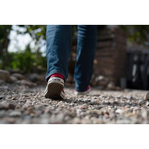 Person geht auf mit ACO Self® Kieswabe befestigtem Zierkiesweg.