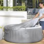 Bestway Lay-Z-Spa St. Lucia AirJet aufblasbarer Whirlpool mit Abdeckung und Mann.