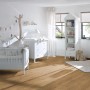 Verlegtes Egger Laminat Classic 8 mm Eiche Matera Honig im Kinderzimmer mit weißen Möbeln.