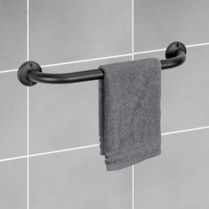Schwarzer Wenko Badewannengriff Basic mit Handtuch an grauer Wand.