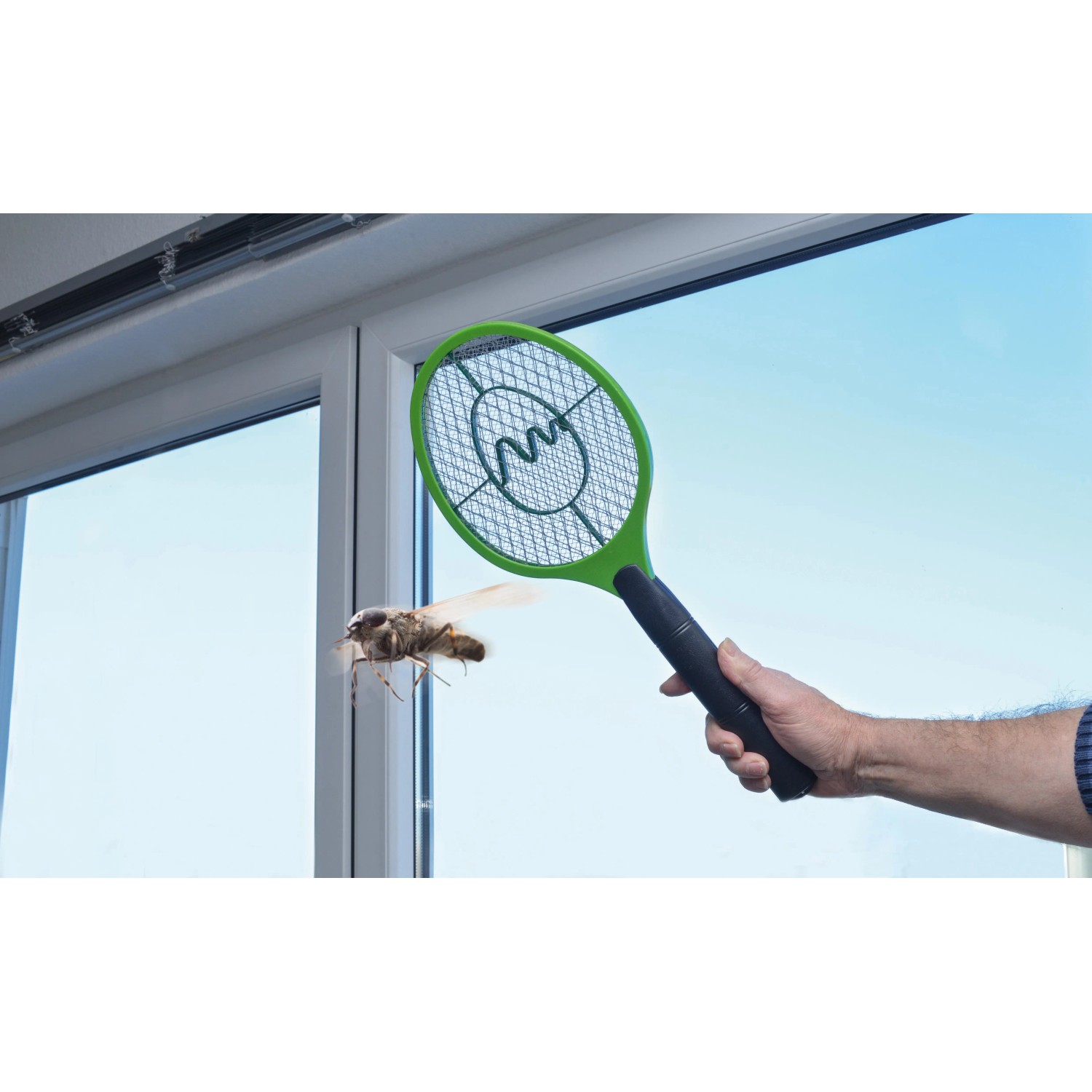 Grüne Gardigo Fliegenklatsche Bzzz im Einsatz gegen eine Fliege vor einem Fenster.