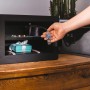 Offener, schwarzer Yale Smart Safe Tresor mit Schmuck und einer Hand, die eine Uhr hineinlegt.
