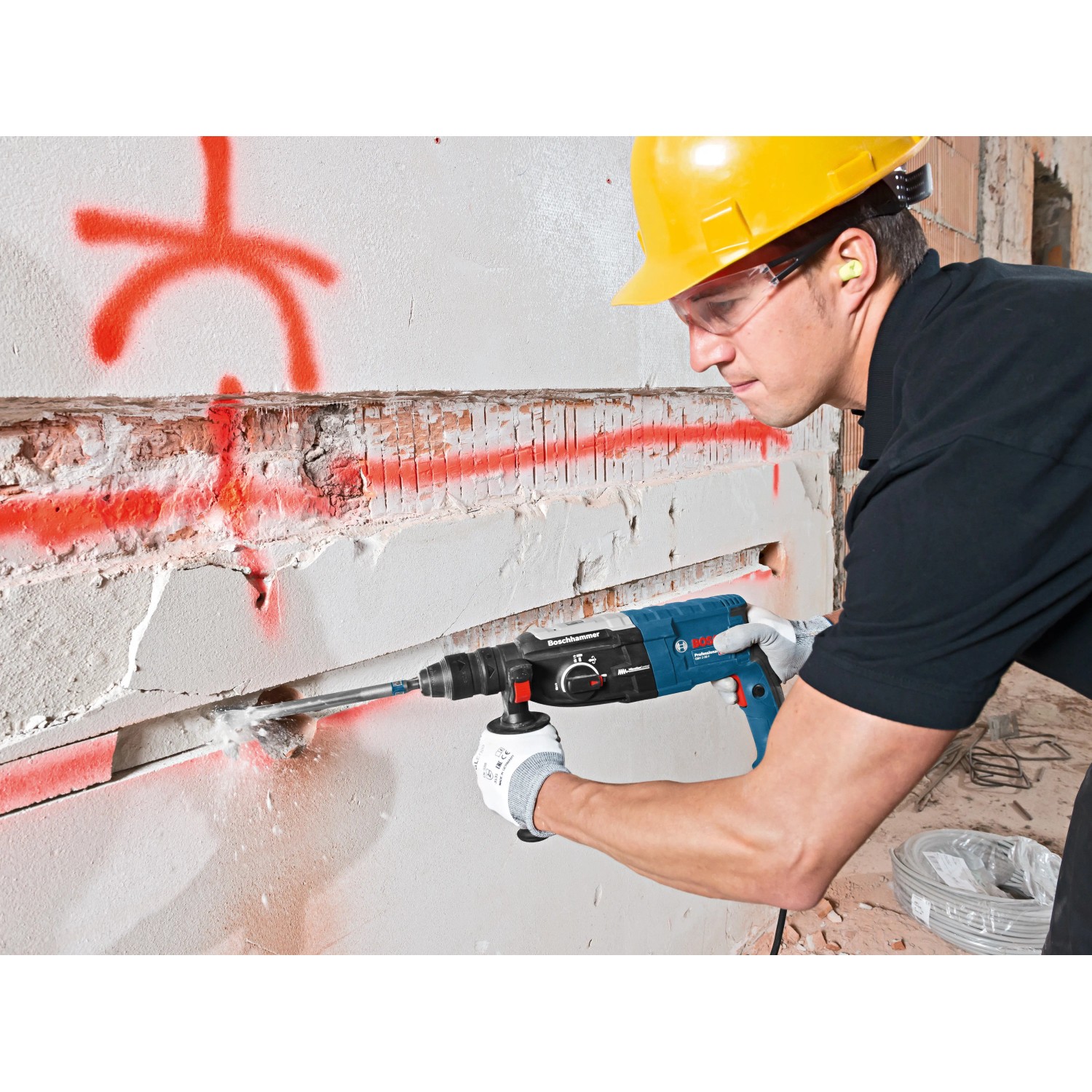 Mann bohrt mit Bosch Professional Bohrhammer GBH 2-28 F in Wand. Inkl. L-Boxx.