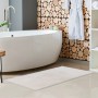 Weißer Lalee Badteppich Heaven, 40x60 cm, im Badezimmer mit Badewanne und Holzdekor.