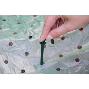 Netz- und Folienhalter (10 Stk.) im Einsatz: Dunkelgrüner Haken fixiert Folie im Beet.