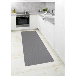 Graue Wenko Badematte (65x200 cm) aus Kunststoff als Küchenläufer vor weißen Küchenmöbeln.
