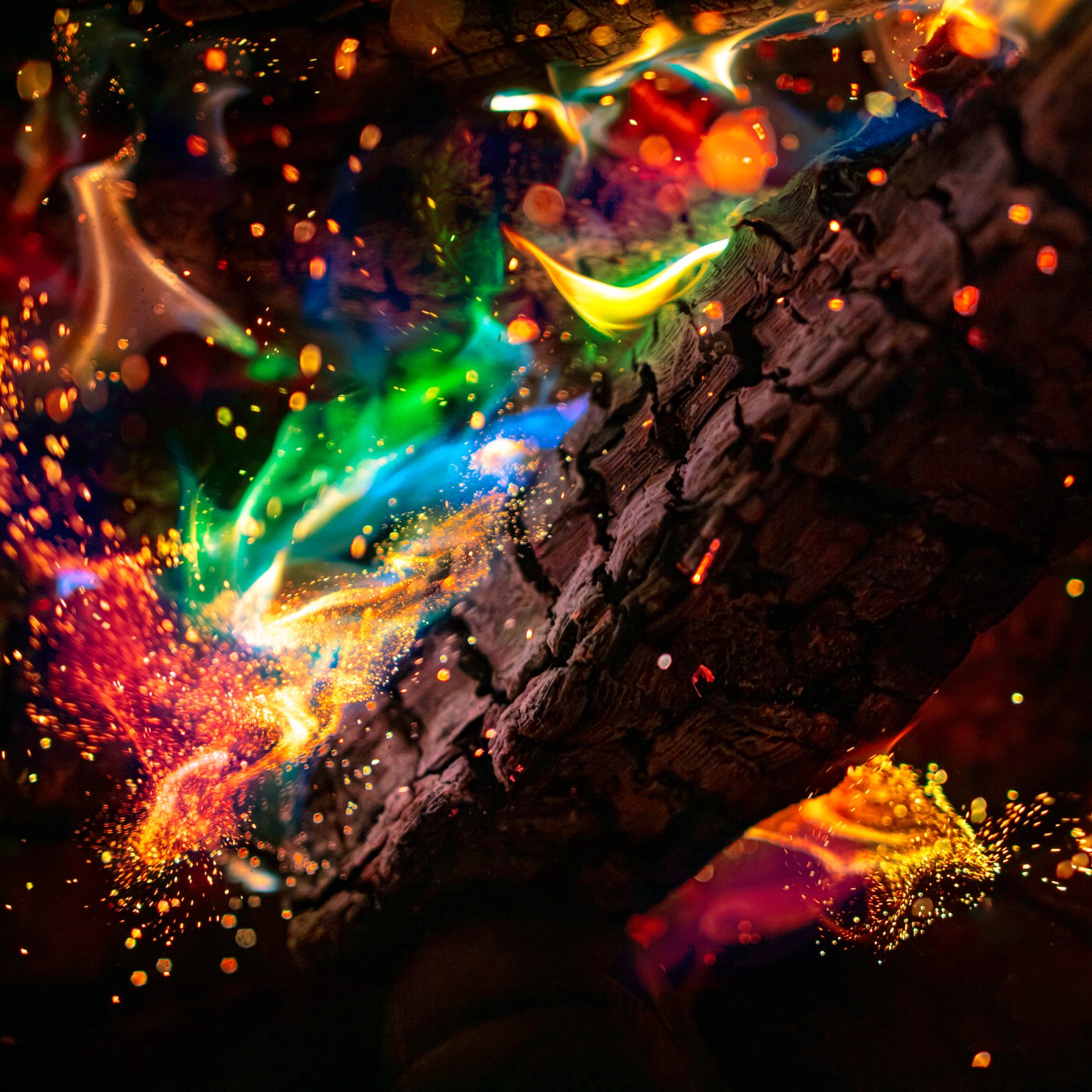 Buntes Feuerholz mit Feuerfarbe in Rot, Gelb, Grün und Blau.