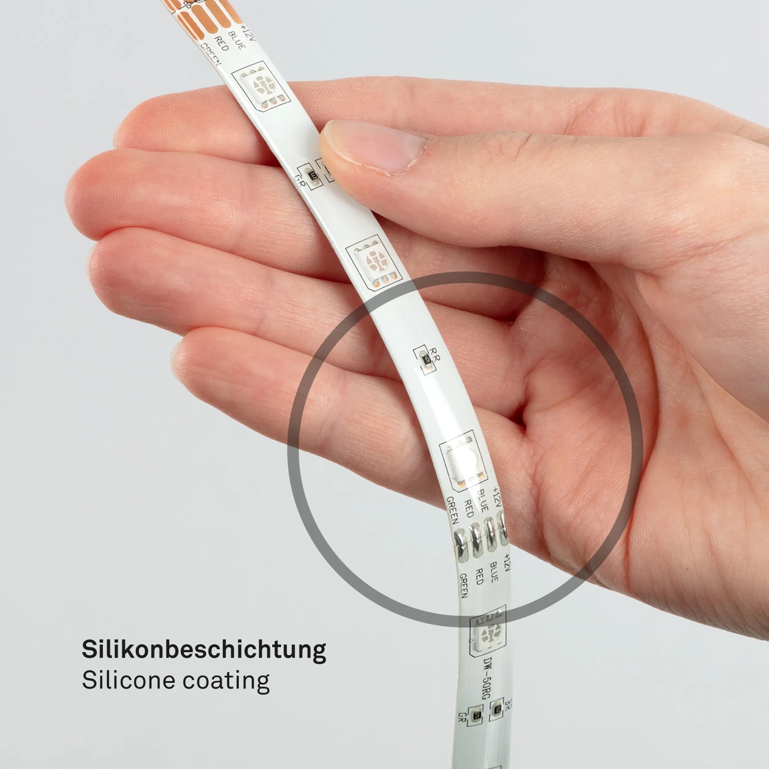Nahaufnahme eines flexiblen, mehrfarbigen LED Streifens in einer Hand.