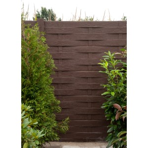 Betonzaun mit Acrylfarbe in Schokolade (RAL 8017) gestrichen, umgeben von Grünpflanzen.