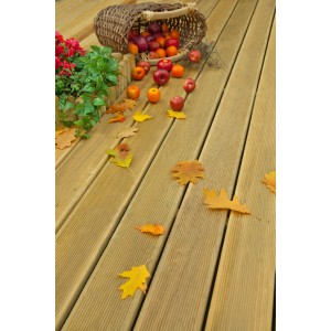 Grüne, druckimprägnierte Nadelholz-Terrassendiele mit Herbstdeko und Früchtekorb.