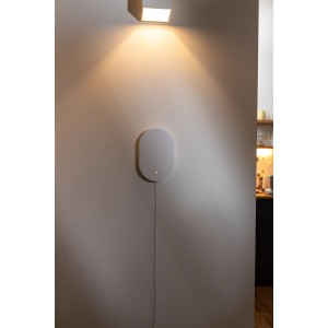 Weiße, ovale Abus Smartvest Pro Funk-Zentrale Alarmanlage an heller Wand, mit gelber LED und Kabel. Modernes Sicherheitssystem.