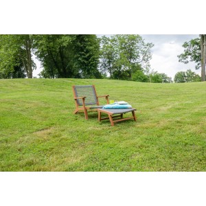 Acamp Relax-Chair Bangkok Teak-Grau mit Hocker auf Rasen, Gartenstuhl aus Akazienholz mit grauem FlexMesh-Geflecht.