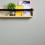 Holzregal mit Pflanze, gelbem Ordner und Bild vor grauer Wand. Dekorative Wandgestaltung.