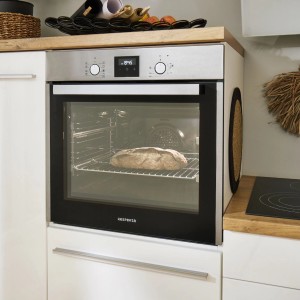Respekta Herdset Diman + Alex: Edelstahl Backofen mit Brot und Induktionskochfeld in moderner Küche.
