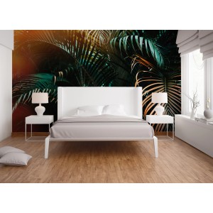 Fototapete mit Palmenblätter Motiv in Grün, Gelb und Orange im Schlafzimmer.