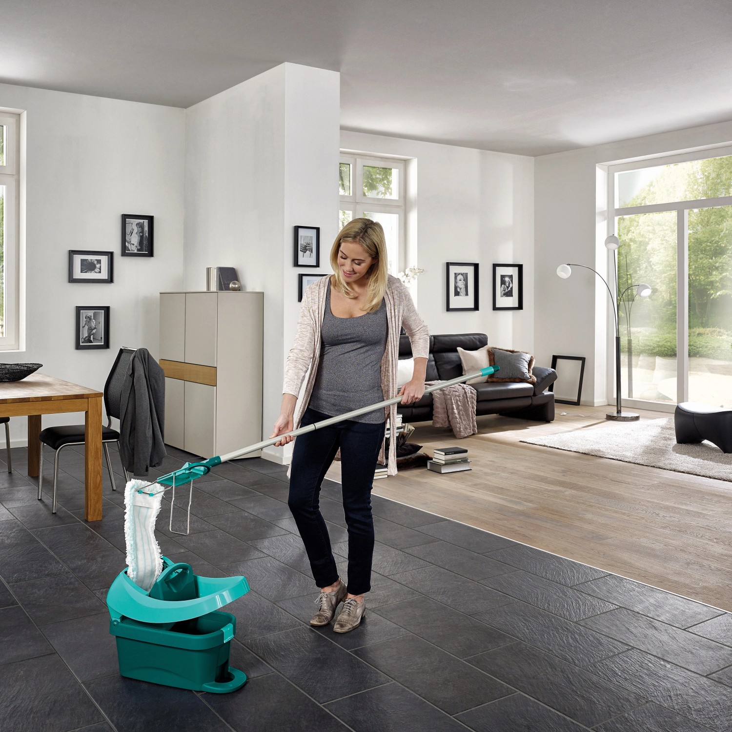 Frau wischt Boden mit Leifheit Bodenwischer mit Wischtuchpresse in modernem Wohnzimmer.