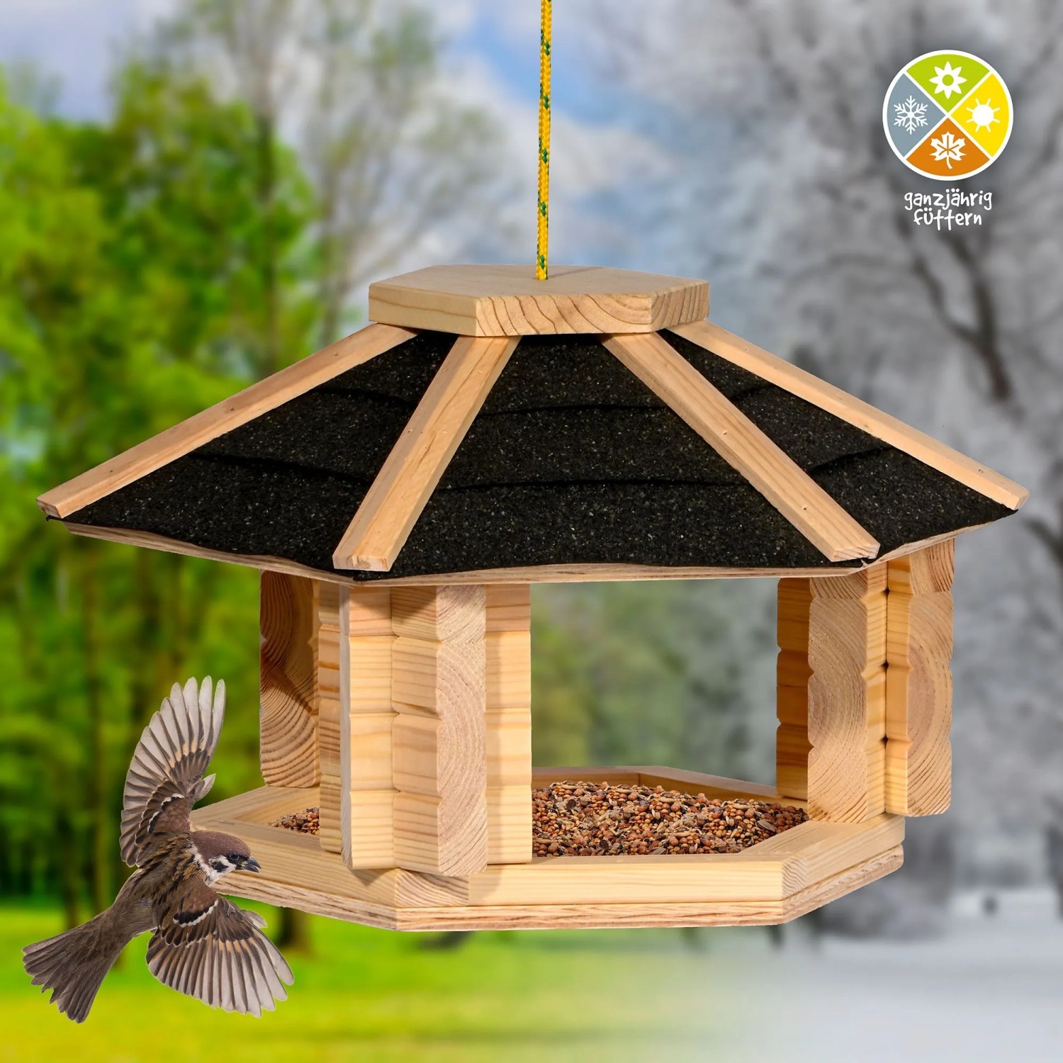 Dobar Vogelhaus Zwart aus hellem Kiefernholz mit schwarzem Bitumendach. Ein Spatz fliegt zum Futterhaus für Wildvögel.