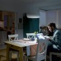 Mann arbeitet unter warmweißem Philips LED-Leuchtmittel E14 6,5W am Tisch.