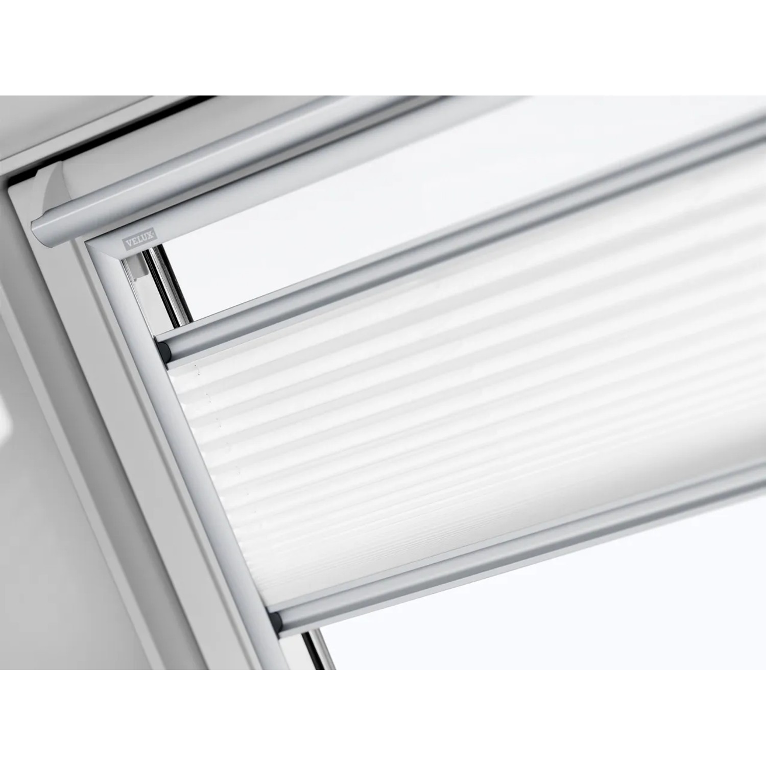 Detailaufnahme: Weißes Velux Plissee FHL C02 1016S am Dachfenster.