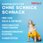 Hund in gelbem Hoodie, leckt sich die Lippen. Supravit Nassfutter mit Pferd, getreidefrei, ohne Konservierungsstoffe.