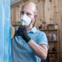 Mann schleift blaue Holzoberfläche mit Bosch Exzenterschleifer und Schleifblatt C470 K60.