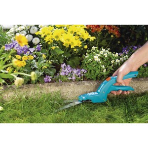 Gardena Grasschere Classic im Einsatz zum Rasenkantenschneiden. Handliche Gartenschere mit blauem Griff.