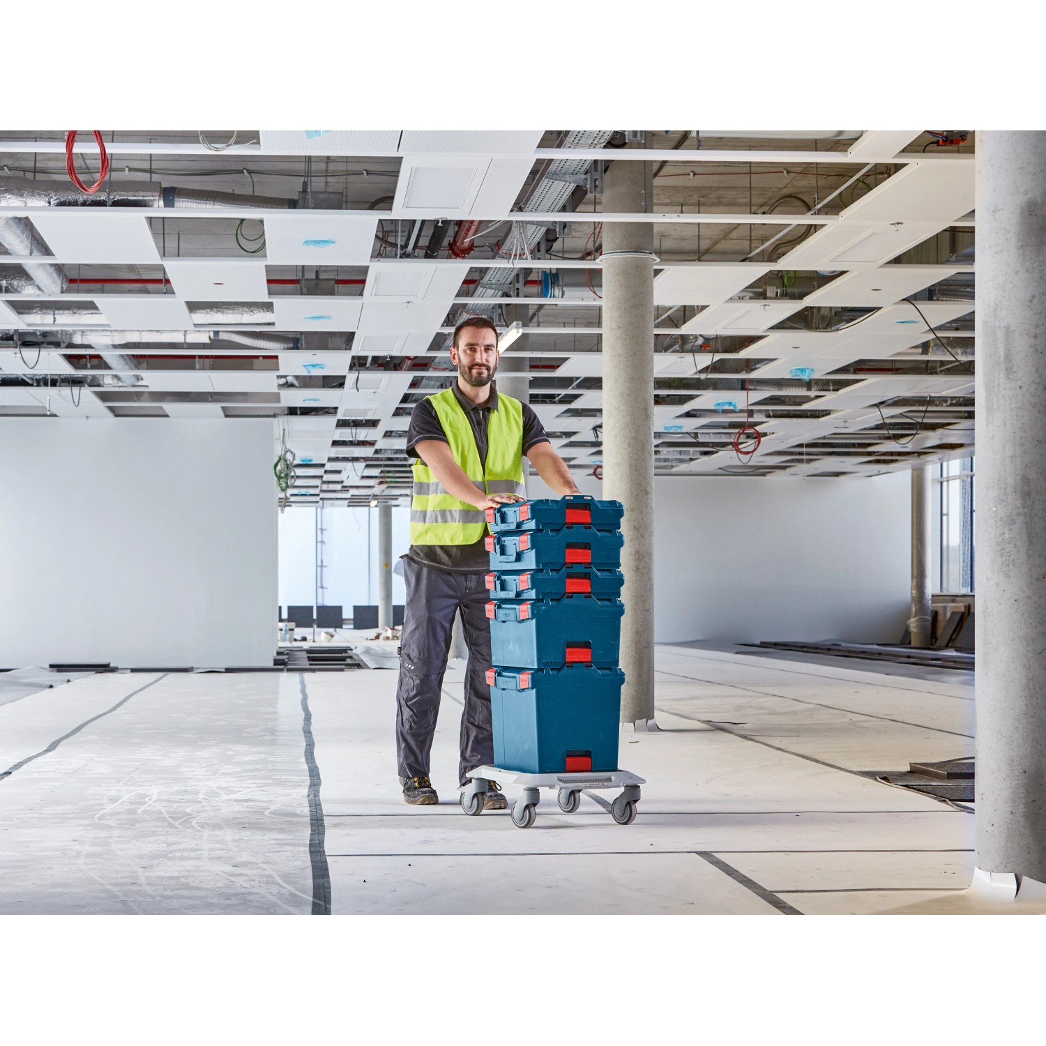 Bosch Professional L-Boxx 102 Werkzeugkiste auf Rollbrett mit Handwerker in Halle.