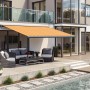 Anthrazit Kassettenmarkise Wismar mit gelb-orangem Stoff, ausgefahren über einer Terrasse.