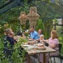 Familie beim Essen im Juliana Gewächshaus Orangerie 21 Schwarz-Anthrazit. Gemütliche Atmosphäre im Garten.