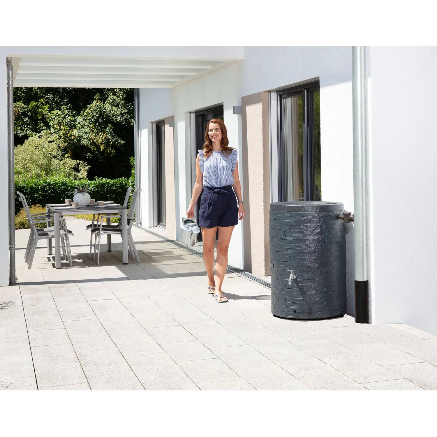 Garantia Regenspeicher Muro 260 l in Grau mit Wasserhahn und Steinoptik auf Terrasse.