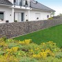Gabionen-Basisbausatz Limes als flexible Gartenmauer/Sichtschutz, gefüllt mit grauen Steinen.
