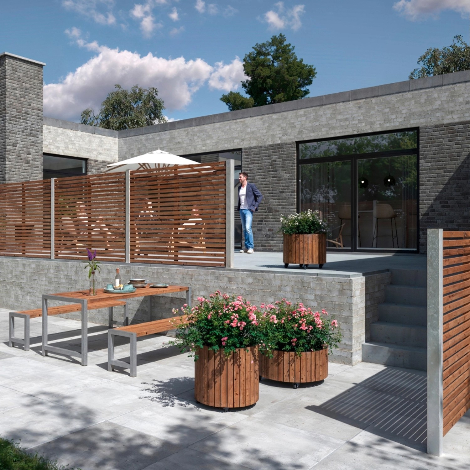 Sichtschutzzaun Tokyo ThermoWood® (180x140cm) im Gartenambiente mit Tisch und Bepflanzung.