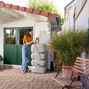 Garantia Gartentank Cubus 340 l betongrau mit Frau und Schlauch im Garten.